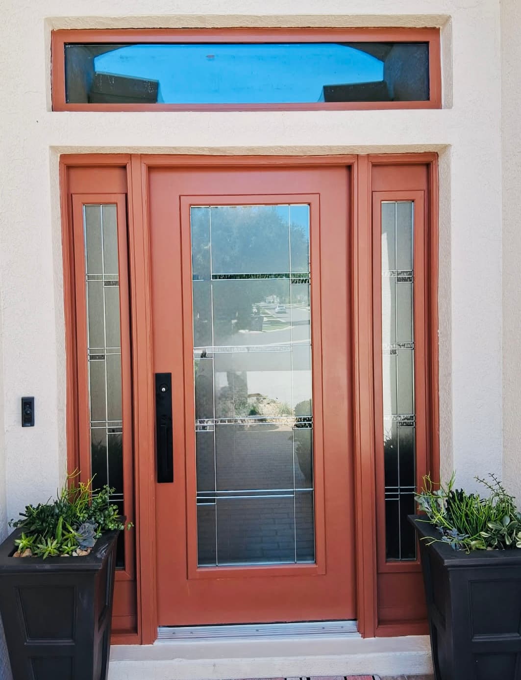 Custom terracotta painted entry door with sidelights in Sarasota